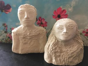 two ceramic humans with blue sky flowers background, fine ceramic art 8 inch height
